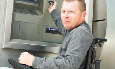 rolstoelpatiënt aan bankautomaat