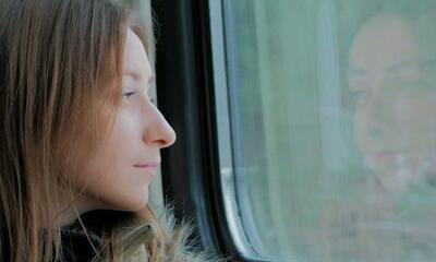 Vrouw kijkt naar buiten op trein NMBS
