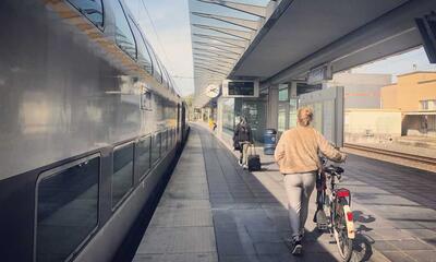 Fietser met fiets aan station NMBS in Brugge