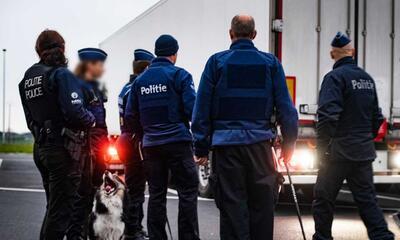 Politie met hond bij vrachtwagen voor transmigranten