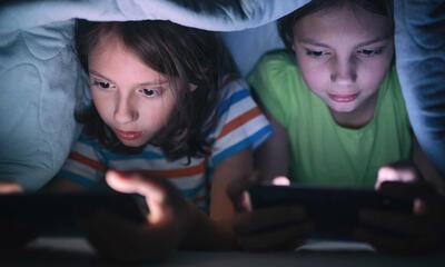 twee kleine kinderen spelen een spelletje op hun smartphone