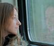 Vrouw kijkt naar buiten op trein NMBS