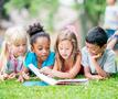 Kinderen lezen boek in het gras
