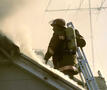 brandweerman blust brand op dak van woning