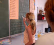 kind schrijft op schoolbord