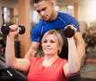 mannelijke fitnesscoach helpt dame bij het sporten