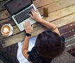 vrouw buiten aan het werk met koffie en laptop